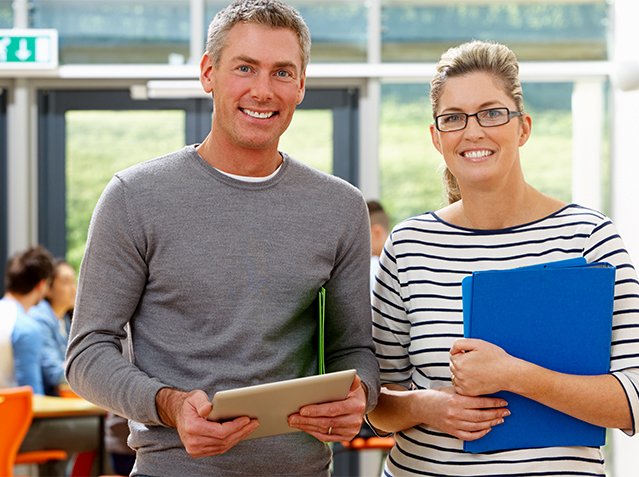 Portrait Of Male And Female Tutors In Classroom